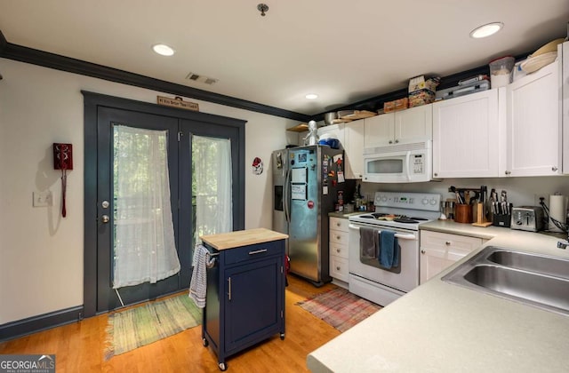 kitchen featuring white appliances, light wood-type flooring, blue cabinetry, ornamental molding, and white cabinetry