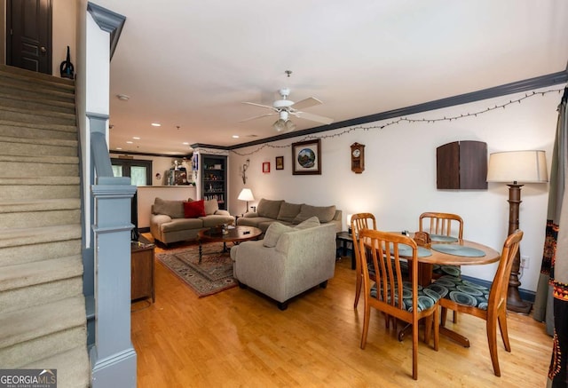 living room featuring ceiling fan, crown molding, and light wood-type flooring