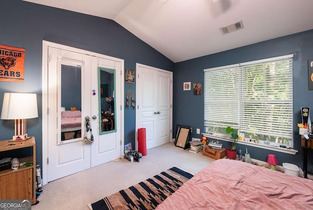 bedroom featuring vaulted ceiling, light carpet, and multiple windows