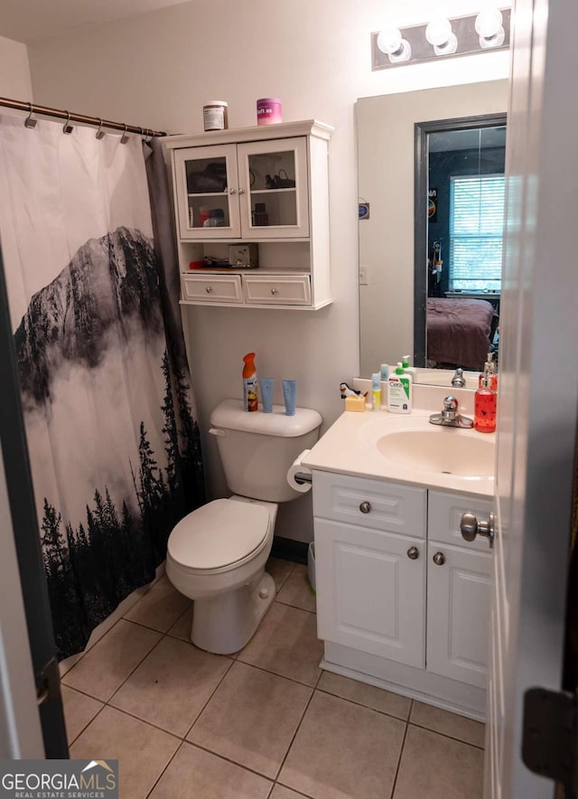 bathroom featuring toilet, vanity, and tile patterned floors