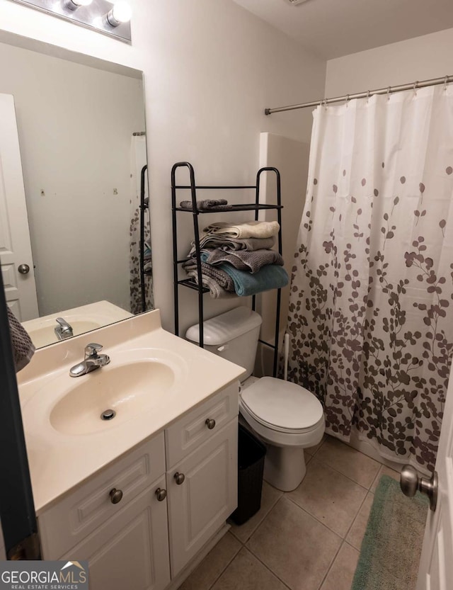 bathroom with tile patterned flooring, vanity, and toilet