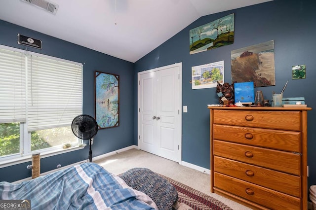 carpeted bedroom featuring a closet and lofted ceiling