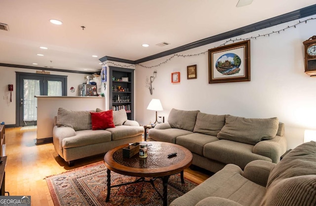 living room featuring french doors, light hardwood / wood-style floors, and ornamental molding