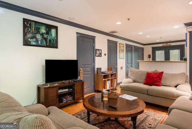 living room featuring light hardwood / wood-style floors and ornamental molding