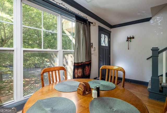 dining area with wood-type flooring and ornamental molding