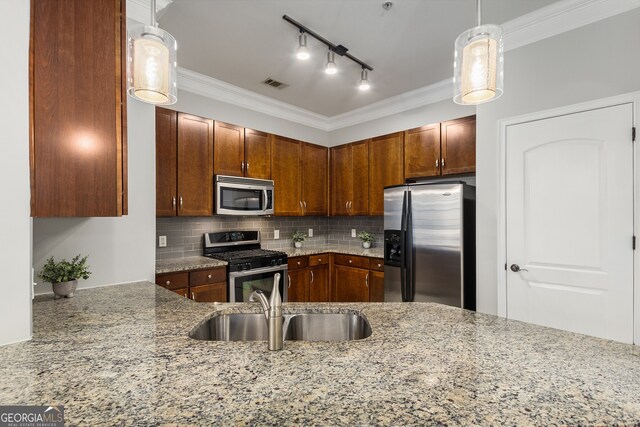 kitchen featuring sink, rail lighting, tasteful backsplash, light stone counters, and stainless steel appliances