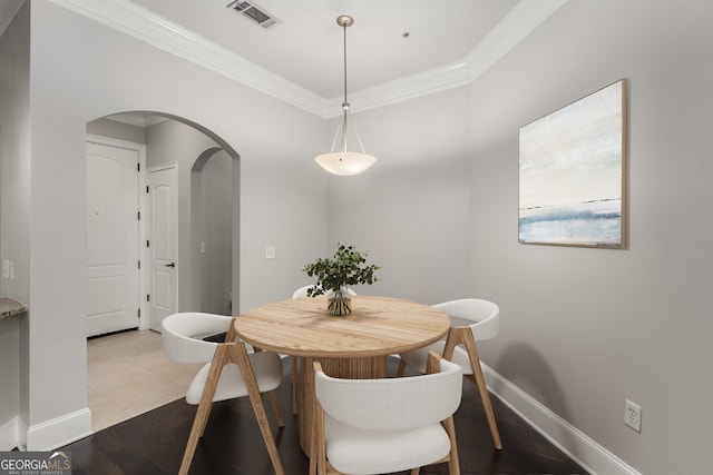 dining room featuring light tile patterned floors and crown molding