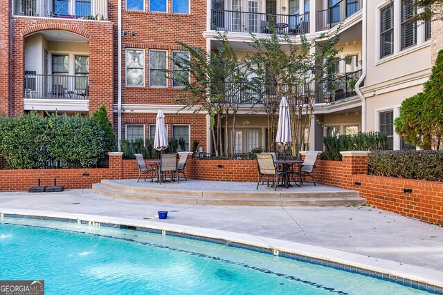 view of pool featuring pool water feature and a patio