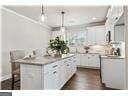 kitchen with white cabinetry, breakfast area, and hanging light fixtures