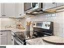 kitchen with electric range and white cabinetry