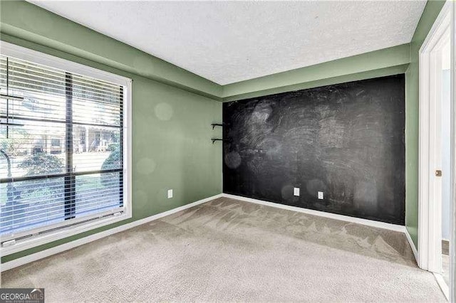 carpeted spare room featuring a textured ceiling