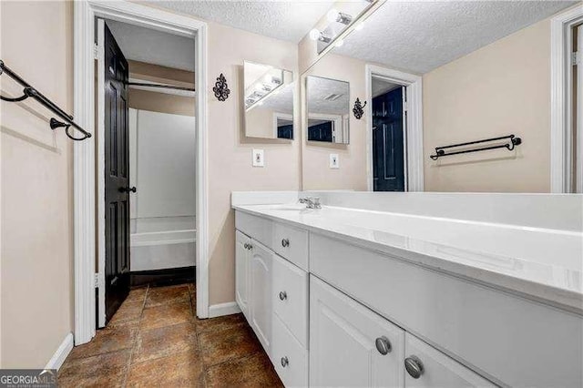 bathroom with a textured ceiling and vanity