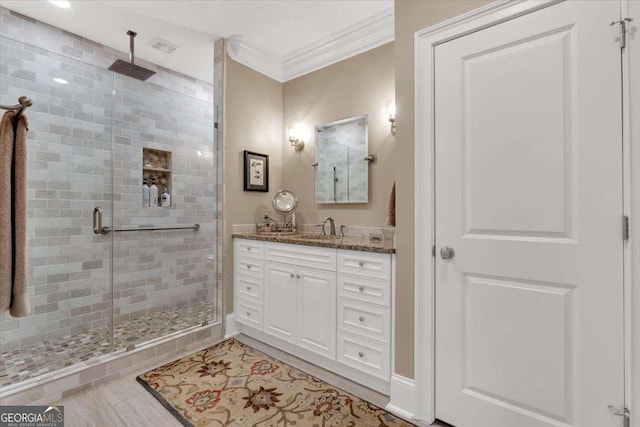 bathroom featuring vanity, tile patterned floors, a shower with shower door, and ornamental molding