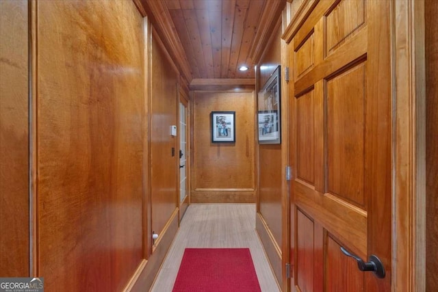 hall featuring wooden ceiling and wooden walls