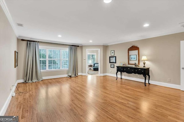 interior space with ornamental molding and light hardwood / wood-style flooring