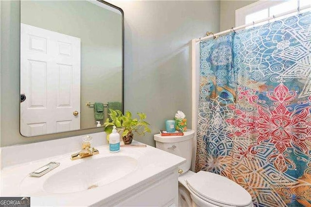 bathroom with a shower with curtain, vanity, and toilet