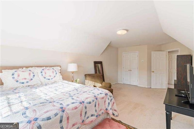 carpeted bedroom featuring a closet and lofted ceiling