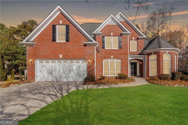 view of property with a garage and a lawn