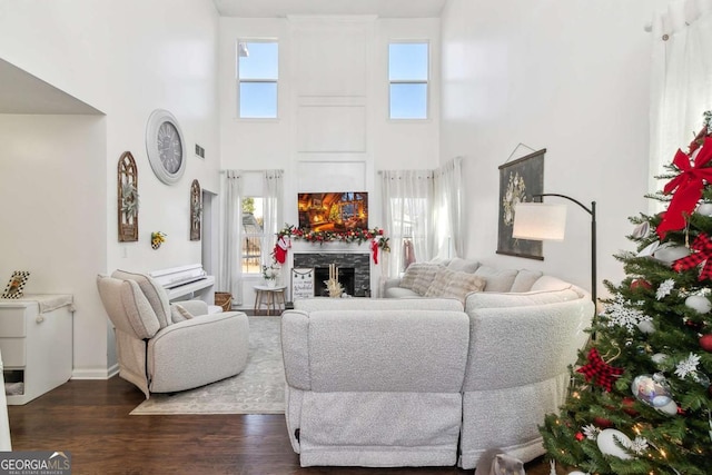 living room featuring a fireplace, a high ceiling, and dark hardwood / wood-style floors