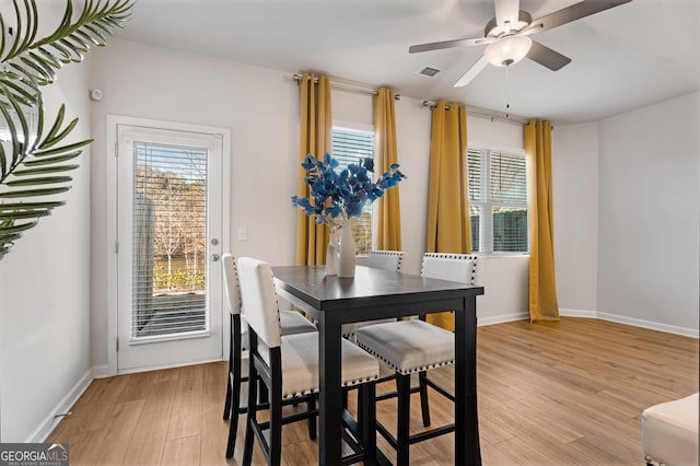 dining space with light hardwood / wood-style floors and ceiling fan