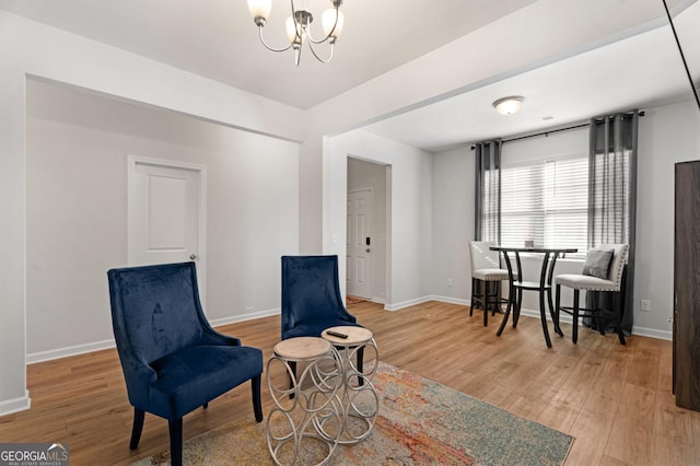 living area with wood-type flooring and an inviting chandelier