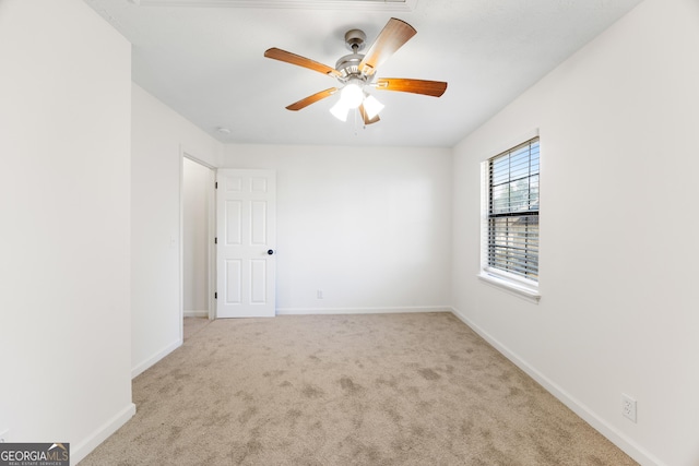 carpeted spare room with ceiling fan