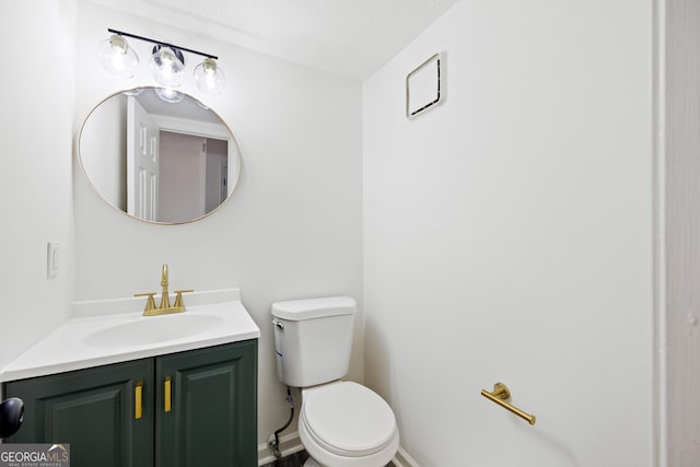 bathroom featuring vanity, toilet, and a textured ceiling