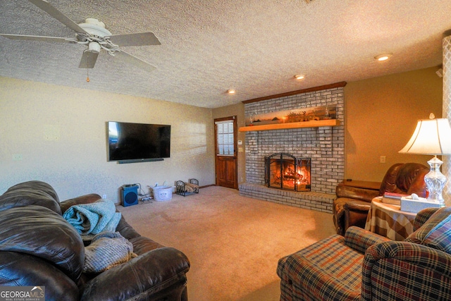 living room featuring a textured ceiling, ceiling fan, a fireplace, and carpet