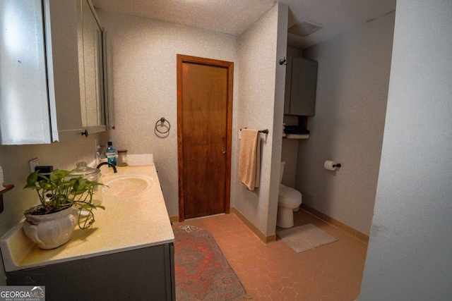 bathroom featuring tile patterned floors, vanity, and toilet