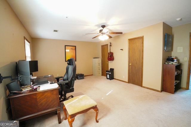 carpeted office space featuring ceiling fan