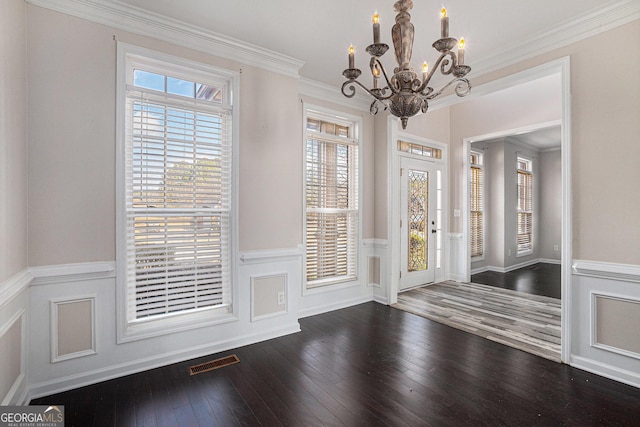 entryway with visible vents, ornamental molding, hardwood / wood-style flooring, wainscoting, and a chandelier