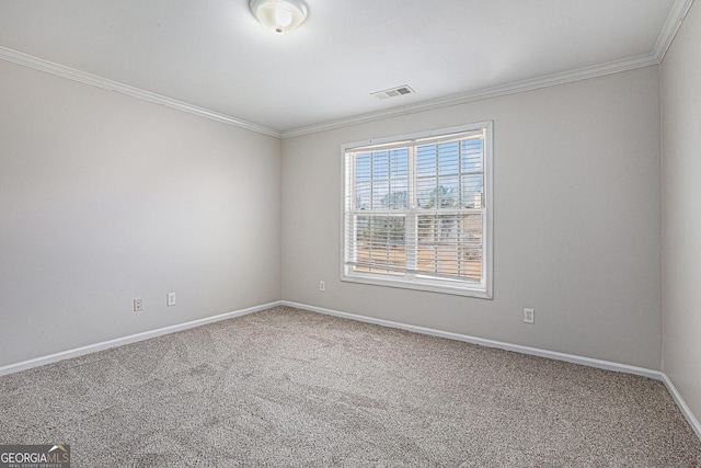 spare room featuring visible vents, baseboards, carpet flooring, and crown molding