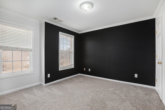carpeted empty room with crown molding, baseboards, visible vents, and a wealth of natural light