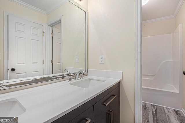 full bathroom with crown molding, double vanity, and a sink