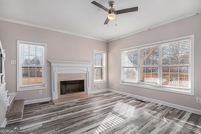 unfurnished living room with crown molding, wood finished floors, baseboards, and ceiling fan