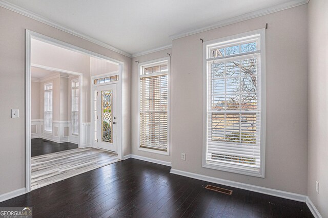 foyer featuring visible vents, crown molding, dark wood-type flooring, and baseboards