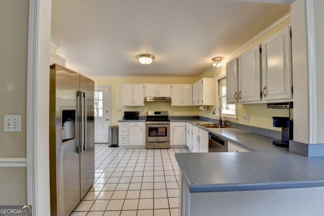 kitchen featuring white cabinets, appliances with stainless steel finishes, light tile patterned floors, and sink