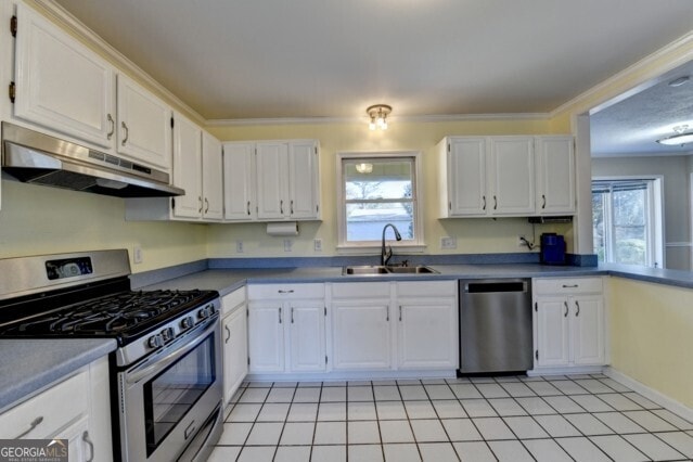 kitchen featuring stainless steel appliances, crown molding, sink, white cabinets, and light tile patterned flooring