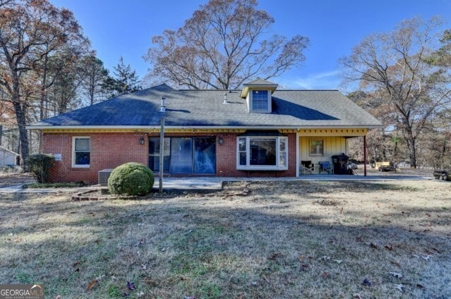 rear view of house with a yard and a patio