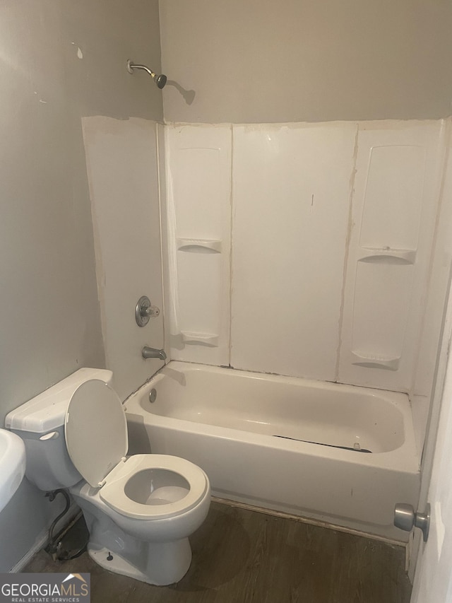 bathroom featuring hardwood / wood-style flooring, toilet, and shower / bathing tub combination