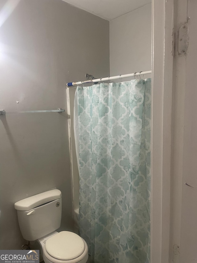 bathroom with shower / tub combo and toilet