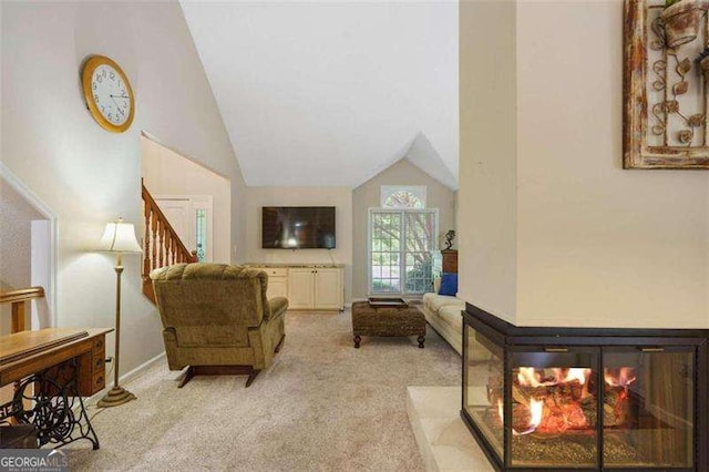 living room featuring a multi sided fireplace, light colored carpet, and vaulted ceiling