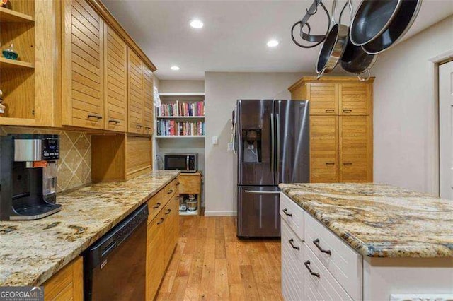 kitchen with backsplash, stainless steel refrigerator with ice dispenser, light stone countertops, black dishwasher, and white cabinetry