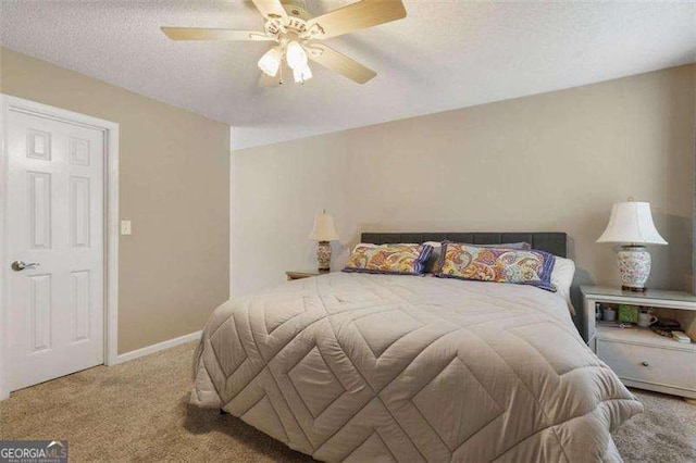 carpeted bedroom with ceiling fan and a textured ceiling