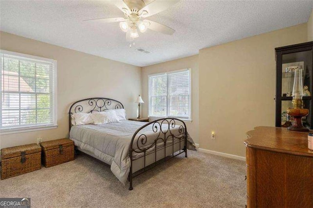 bedroom with light carpet, a textured ceiling, and ceiling fan