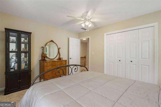 bedroom with light carpet, a textured ceiling, a closet, and ceiling fan