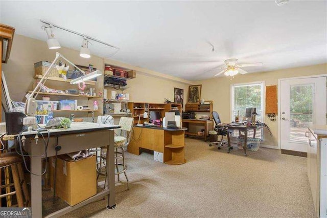 carpeted office space with ceiling fan and track lighting