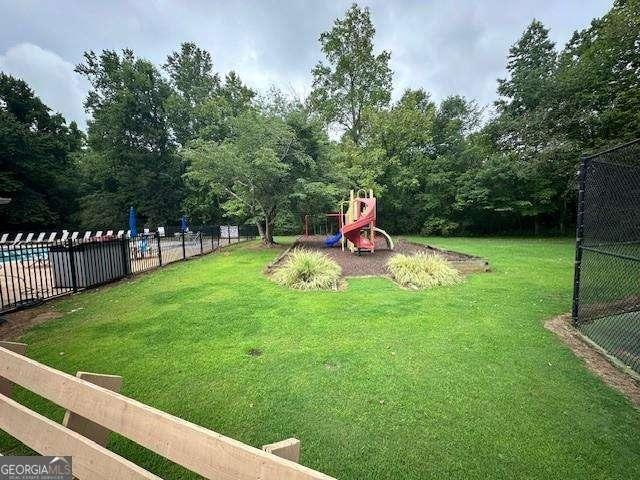 view of yard with a playground and a community pool