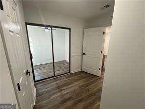 unfurnished bedroom with dark wood-type flooring and a closet