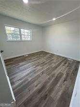 empty room with dark wood-type flooring